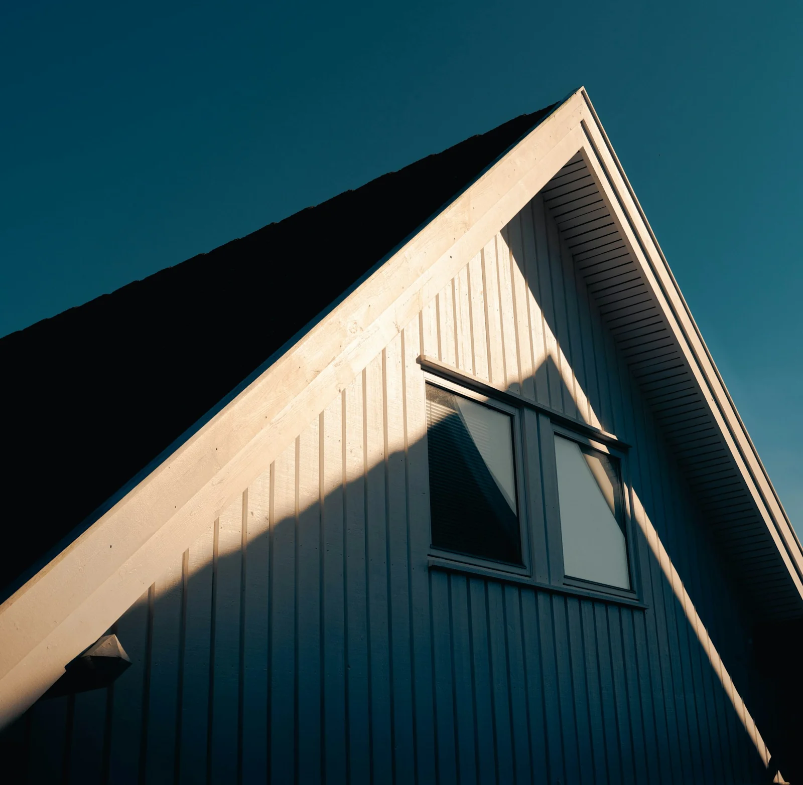 Residential gable roof against a blue sky